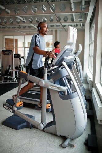 Man using elliptical machine at gym